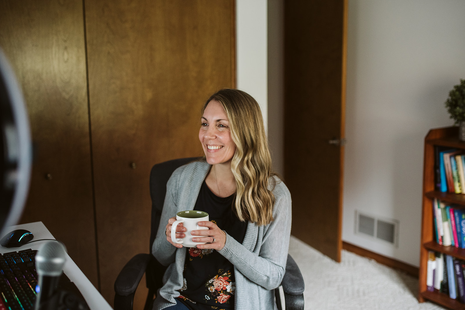 Shawn seated in her office holding a mug