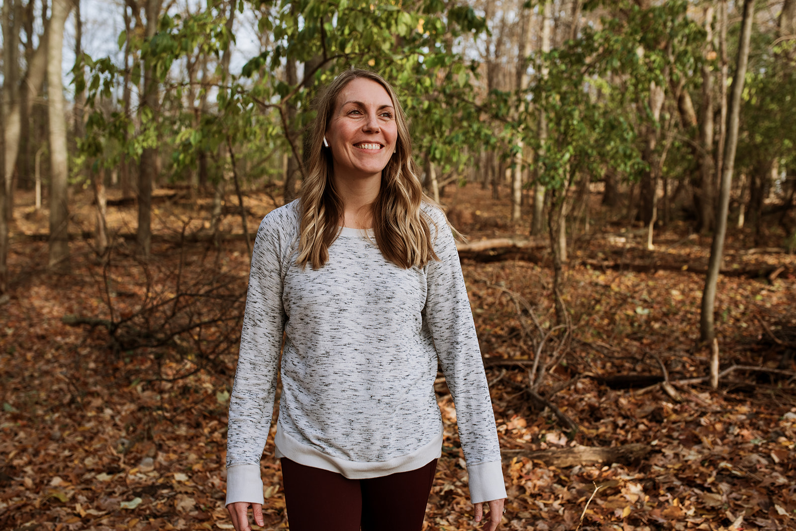 Shawn standing in an autumn woods, smiling and looking up
